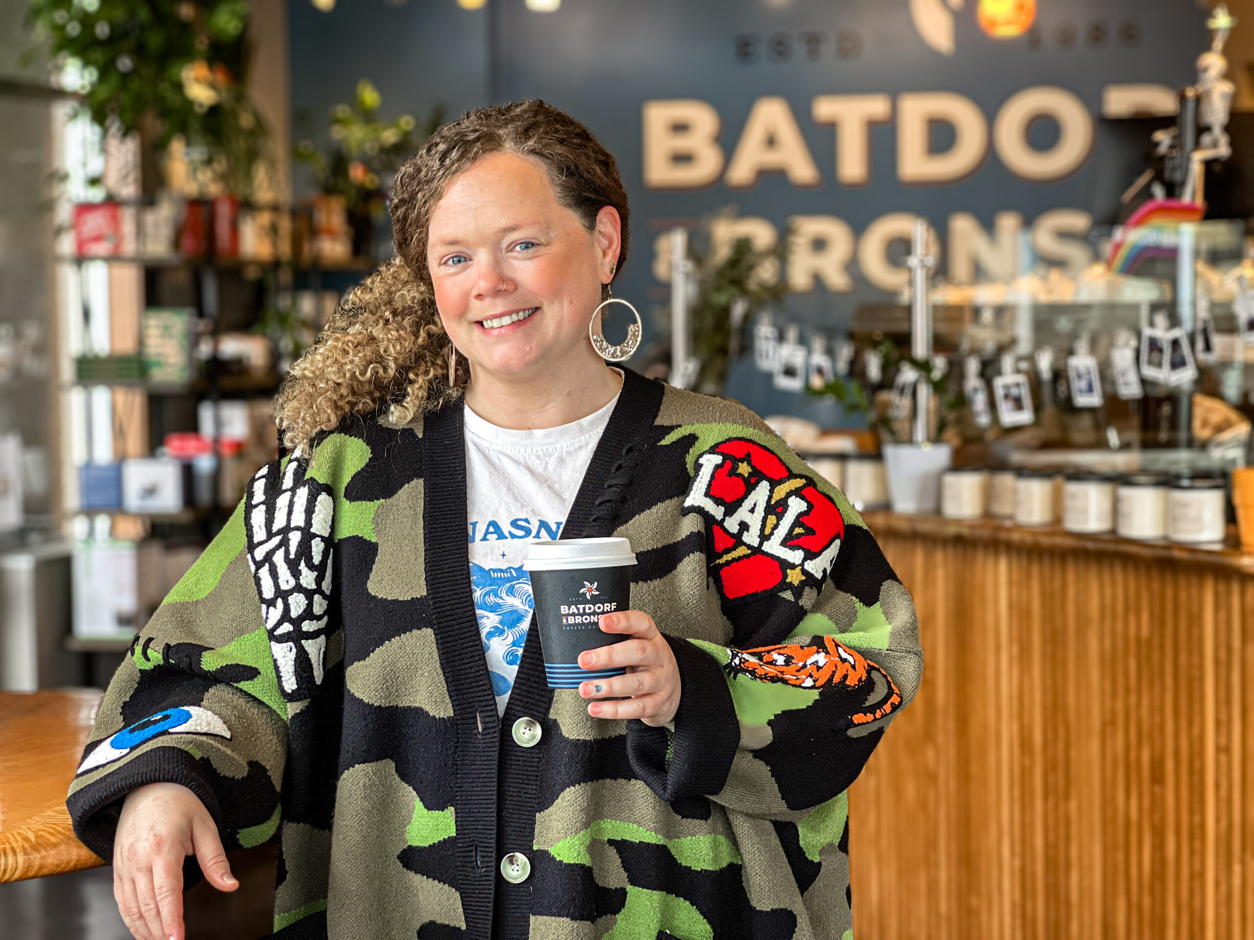Krista Bentow, owner of Batdorf & Bronson Legacy Cafe in downtown Olympia, holding a coffee inside the cafe